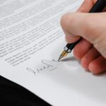 Image of a person signing a document with a fountain pen
